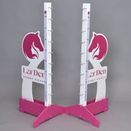 Due supporti LarDen jump 110 cm / 43 inch rosa e bianchi di Hobby Horse LarDen con disegni di teste di cavallo, indicatori di altezza regolabile e supporti metallici per la barra, su sfondo grigio. Sulla base è stampato "LarDen HOBBY HORSE".
