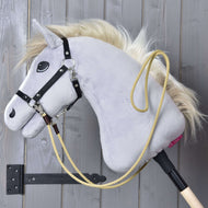 Hobby Horse LarDen Redini Western Dakota, un Hobby Horse grigio con criniera bionda, briglia nera e corda gialla con ganci a scatto, appeso a una parete di legno in un supporto nero, perfetto per sessioni di allenamento.
