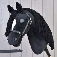 Hobby Horse Cloony con Cavezza Nera di Hobby Horse LarDen, stallone American Quarter Horse in peluche con tessuto nero, macchia bianca sul muso, occhi a bottone, criniera in filato nero e briglia, su sfondo in legno chiaro.