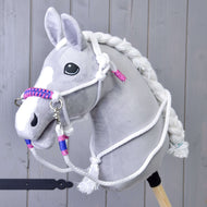 Set Lunghina Bianca (taglia M) di Hobby Horse LarDen con Hobby Horse di peluche grigio con criniera bianca, redini e cavezza intrecciata con dettagli rosa e blu, mostrato su sfondo in legno.