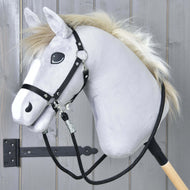 Hobby Horse - Redini nere di Hobby Horse LarDen, con testa grigia in peluche, briglia nera, redini in paracord e criniera bianca su un bastone di legno, esposto davanti a pannelli di legno grigi con una cerniera in metallo nera visibile.