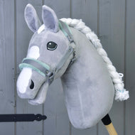 Cavezza grigia con pelliccia color menta di Hobby Horse LarDen, accessorio per Hobby Horse in peluche grigio con criniera bianca e marcature facciali, su sfondo in legno grigio.