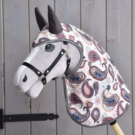 Hobby Horse LarDen in tessuto con muso grigio, briglia nera e copertura colorata con motivo paisley, davanti a pannelli in legno, che indossa l'Impermeabile Fatina Blu (softshell) coordinato per maggiore fascino e protezione.