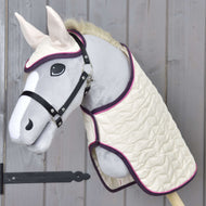 Hobby Horse LarDen Set Supreme Crema su un Hobby Horse con muso grigio in peluche, musello e orecchie bianchi, vestito con coperta trapuntata color crema e cuffia per orecchie abbinata con bordo viola, esposto su una parete in legno.