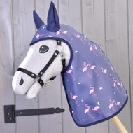 Un Impermeabile Flamingo di Hobby Horse LarDen, un Hobby Horse grigio con cappuccio impermeabile blu navy con fenicotteri rosa, posizionato davanti a una parete di legno con una cerniera metallica nera.