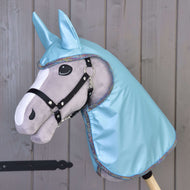 Hobby Horse grigio Hobby Horse LarDen con briglia nera, grandi occhi in feltro e cappuccio Impermeabile Azzurro Chiaro con orecchie abbinate, mostrato davanti a una parete di legno.