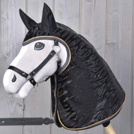 Hobby Horse realistico con muso bianco, criniera nera e briglia nera davanti a uno sfondo di pannelli in legno chiaro, che indossa l'Impermeabile Luxury di Hobby Horse LarDen.