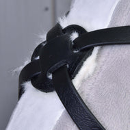 Primo piano di cinghie nere in pelle e del fissaggio del nasello in similpelle del Nasello Mexico Nero Imbottito di Hobby Horse LarDen, che tengono insieme morbido tessuto peloso bianco e grigio.