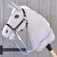 Hobby Horse LarDen Redini Sky con Hobby Horse in peluche grigio, briglia nera, corda blu in polipropilene e redini artigianali su bastone in legno, mostrato davanti a una parete in legno.