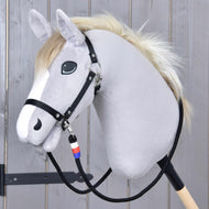 L'Hobby Horse in peluche Hobby Horse LarDen presenta un muso grigio chiaro, briglia nera, criniera bianca ed è montato su un bastone di legno. Include le redini artigianali "Redini Emblema CZ" adornate con un ciondolo blu, bianco e rosso.