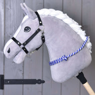 Redini a collare con striscia blu Hobby Horse LarDen, Hobby Horse grigio in peluche con criniera bianca, cavezza nera e cordeo a righe blu, montato su un bastone di legno e mostrato davanti a una parete di legno grigia.