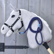 Hobby Horse LarDen Hobby Horse - corda a righe Blues con Hobby Horse in peluche grigio, briglia nera e guinzaglio blu su bastone in legno, mostrato davanti a una parete in legno grigio.