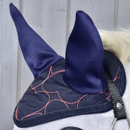Primo piano di un cavallo che indossa la Cuffia Rosa a Cuore di Hobby Horse LarDen per un'elegante protezione antimosche, con cuori rosa e cinghia nera, su sfondo in legno chiaro.