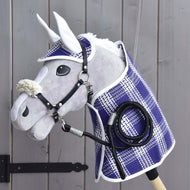 Set Cube Hobby Horse LarDen, composto da coperta, cuffia, lunghina e cavezza con pelliccia, esposto su una parete di legno vicino a una cerniera nera del cancello.