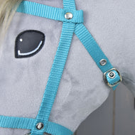 Primo piano di un cavallo giocattolo in peluche in tessuto grigio chiaro, con occhio cucito bianco e nero e Briglia nera con redini in cinghia turchese di Hobby Horse LarDen.