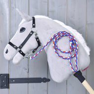 The Hobby Horse LarDen Hobby Horse - rope stripe Flag CZ features a gray body, white mane, black bridle, and a braided red, white, and blue leash on a wooden stick, shown leaning against a light gray wooden wall.