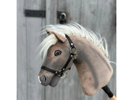 Hobby Horse Happy Boy con capezza nera di Hobby Horse LarDen, un Hobby Horse cavallo hannoveriano grigio e bianco con capezza nera e criniera bianca, esposto su sfondo in legno con cerniere e chiavistello in metallo.