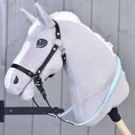 Un Hobby Horse di peluche grigio con criniera bianca e Redini gommate Light blue di Hobby Horse LarDen, fissato a un bastone di legno, davanti a una parete di legno grigia.