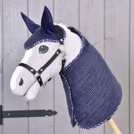 The Hobby Horse LarDen Set Manchester Blue Star features a gray hobby horse with a black bridle and reins, plus a navy blue quilted blanket and ear bonnet with white trim, shown on a wooden stick against a light wood paneled background.