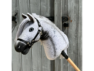 Hobby Horse Naivy con capezza nera di Hobby Horse LarDen esposto davanti a una porta rustica in legno, con livrea Appaloosa grigia e bianca e criniera dettagliata.