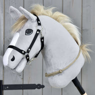 Hobby Horse LarDen Cordeo Eleganza con testa in peluche grigia, briglia nera e criniera beige su un bastone, davanti a tavole di legno, ideale per praticare la monta senza briglia o le tecniche con cordero.