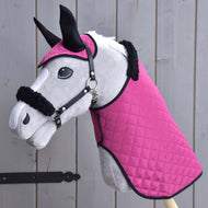 Hobby Horse LarDen Set Pink Beauty (cuffia + coperta + cavezza con pelliccia), Hobby Horse di peluche con coperta trapuntata rosa, cuffia coordinata e cavezza bordata di pelliccia, accessori essenziali, davanti a tavole di legno.