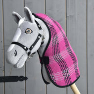 Hobby Horse grigio di Hobby Horse LarDen con briglia nera e Coperta da scuderia Rosa, montato su un bastone di legno e mostrato davanti a una parete di legno grigia.