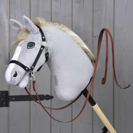 Hobby Horse imbottito grigio di Hobby Horse LarDen con briglia nera e Redini Western Divise Marrone Scuro, montato su un bastone di legno, su sfondo di parete in legno grigio.