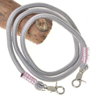 Redini Tizian di Hobby Horse LarDen in polipropilene grigio intrecciato, con moschettoni argentati e avvolgimenti rosa e argento a ciascuna estremità, mostrate su legno su sfondo bianco, ideali come eleganti redini artigianali o per Hobby Horse.