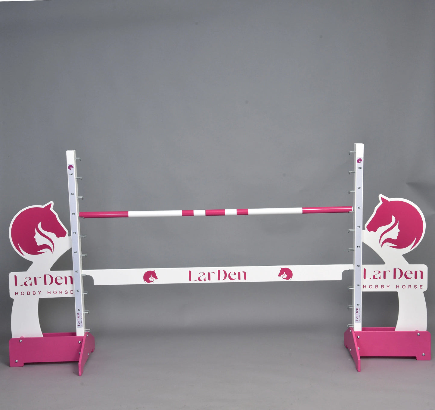 LarDen jump 110 cm / 43 inch di Hobby Horse LarDen con barre rosa e bianche, sagome di teste di cavallo e altezza regolabile, ideale per cavalcare con Hobby Horse. Brand: Hobby Horse LarDen. Su sfondo grigio uniforme.