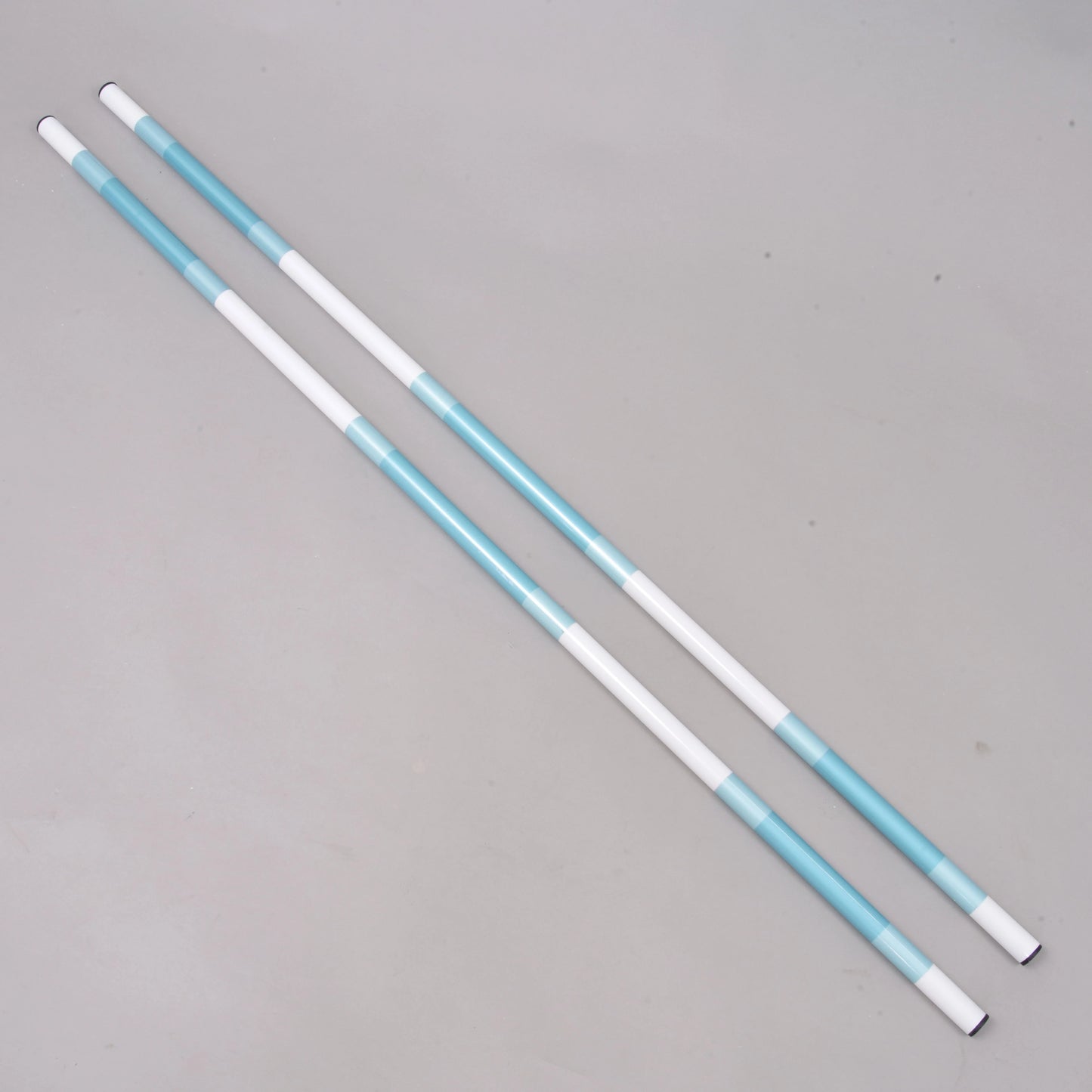 Aste da salto turchese-bianco, 2 pz, di Hobby Horse LarDen, realizzate in PVC rivestito con diametro di 32 mm e sezioni alternate bianche e turchesi, disposte affiancate su una superficie grigio chiaro uniforme.