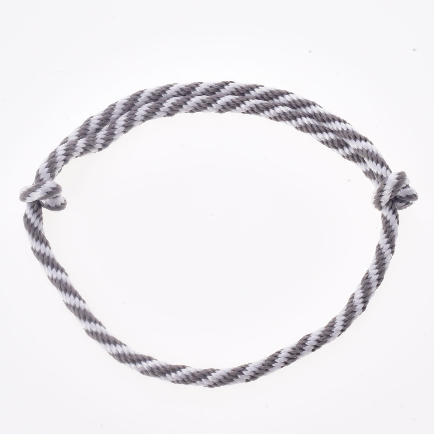 Set Start Argento (cavezza + redini a collare + lunghina + redini) di Hobby Horse LarDen, formato da una corda ritorta grigia e bianca disposta in cerchio con semplici nodi a ciascuna estremità, su sfondo bianco. Ideale come redini o come accessorio con cavezza e lunghina per il tuo Hobby Horse.