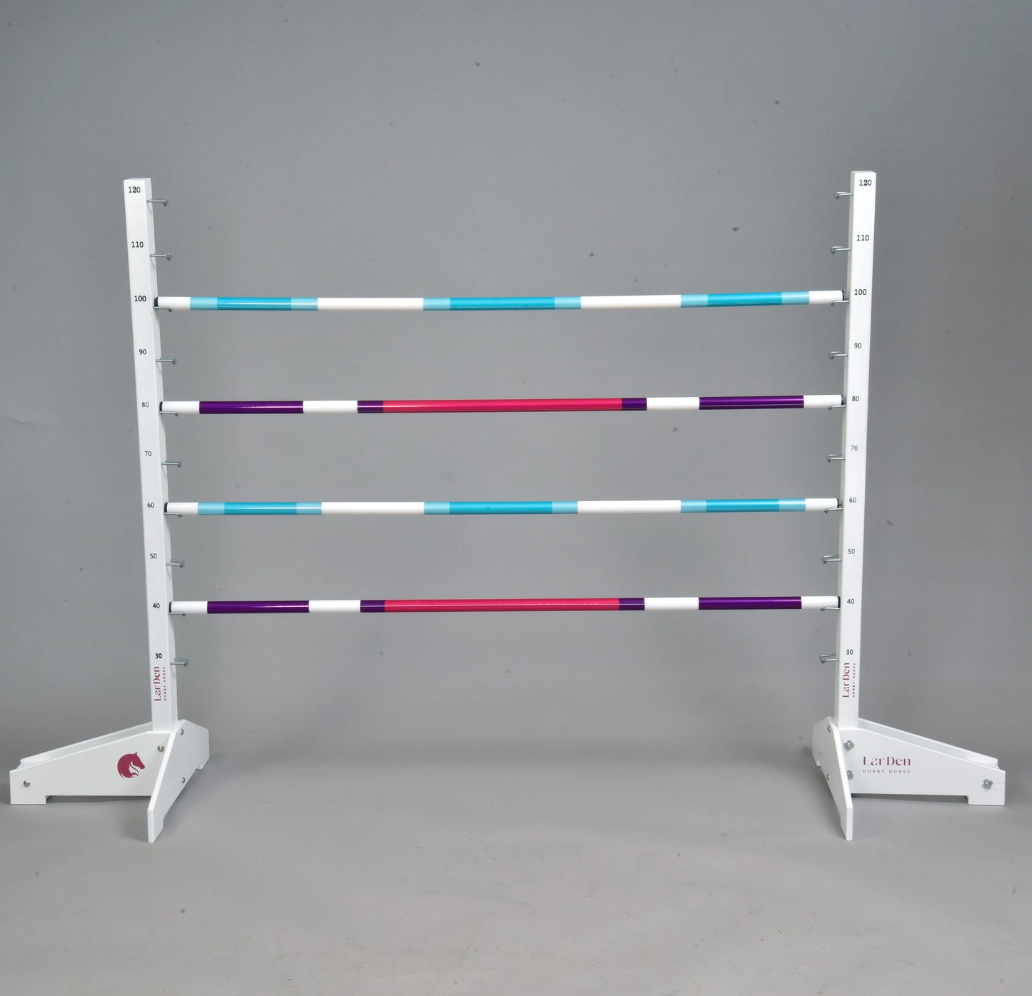 The Hobby Horse LarDen Jump 120 cm / 47 inch with Extra Poles features four horizontal poles in white, turquoise, purple, and red on a height-adjustable white stand—perfect for hobby horsing indoors or outdoors.