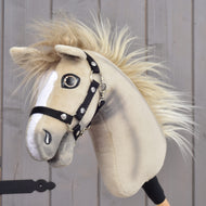 Hobby Horse Ivory Dream con cavezza nera - taglia XS di Hobby Horse LarDen, tenuto in mano da una persona, con manto marrone chiaro, marcature bianche sul muso, criniera soffice e cavezza nera, su sfondo in legno.