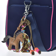 Portachiavi Horse Brown di Hobby Horse LarDen, decorato con una sciarpa colorata e perline arancioni e rosa, su una borsa blu navy con finiture rosa e cinghia blu, perfetto per gli appassionati di Hobby Horsing.