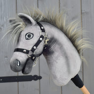 Hobby Horse Prestige con cavezza nera, taglia XS di Hobby Horse LarDen, con design in peluche grigio, criniera appuntita e cavezza nera, ispirato all'eleganza di un English Warmblood. Montato su un bastone di legno e mostrato su sfondo di pannelli in legno.