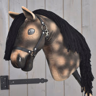The Hobby Horse LarDen “Stormy” features a brown plush head, a black yarn mane, a black halter, and shiny button eyes mounted on a wooden stick against a light wooden background—an enchanting piece inspired by the spirit of a Hanoverian Stallion.
