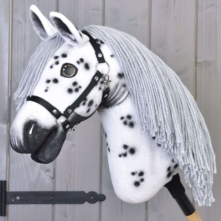 Hobby Horse Chantal con cavezza nera di LarDen, testa in peluche bianca a macchie nere e lunga criniera grigia in filato