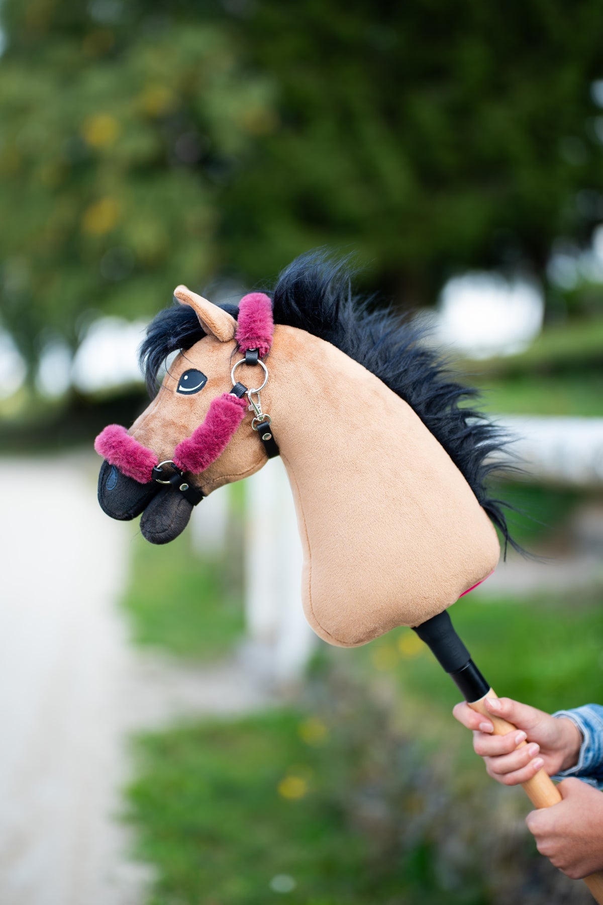 Cavezza con pelliccia per Hobby Horse Teddy Maroon su un Hobby Horse fulvo con criniera nera, tenuto all'aperto