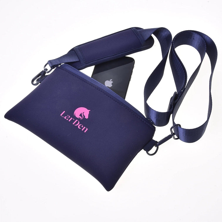 Borsa a tracolla LarDen blu navy con logo rosa, mostrata con cinghia regolabile e uno smartphone nero parzialmente inserito nella tasca con cerniera, ideale per portare l'essenziale al tuo prossimo evento di Hobby Horsing, su sfondo bianco.