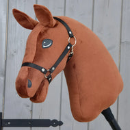 Introducing "Build your horse" by related_to_12441055625556: This custom hobby horse showcases a dark chestnut brown plush head adorned with a black halter and an eye-catching brown and white mane. Mounted on a stick, the horse is beautifully displayed against a gray wooden background.