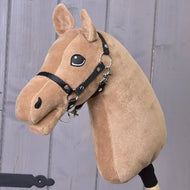 A “Build your horse” plush hobby horse head by related_to_12441055625556, featuring a soft white mane, brown coat, black bridle, and a friendly expression, displayed against a wooden background.