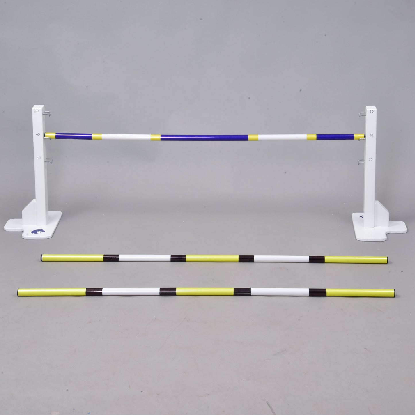 The Hobby Horse LarDen Jump 50 cm / 20 inch with Extra Poles includes three striped poles—two on the ground and one elevated—providing an adjustable obstacle for equestrian, dog agility, or Hobby Horsing training, suitable for indoor or outdoor use.